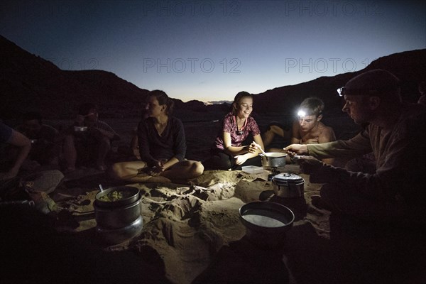 Group of campers cooking on riverbank