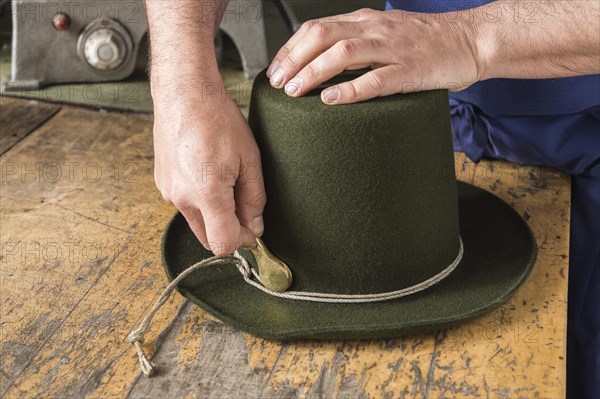 Tightening the shaping cord around a wool felt hat