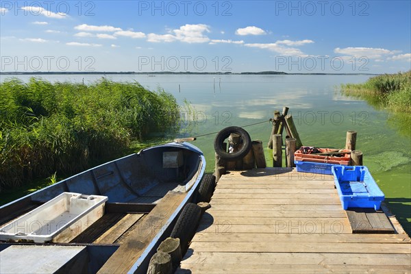 Dock with fishing boat and fish boxes on the Achterwasser