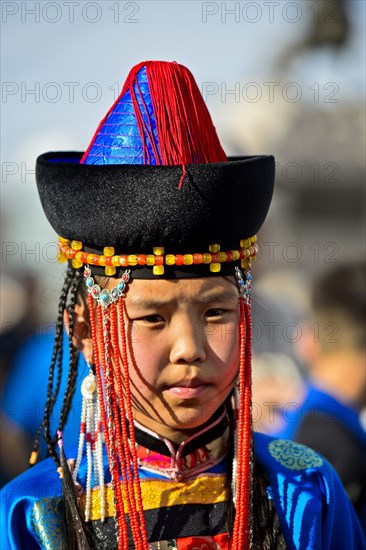 Little girl in traditional Deel clothes and hat with cone-shaped lace