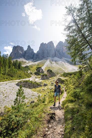 Hikers on the hiking trail to the Geisleralm in the Villnosstal valley below the Odle peaks