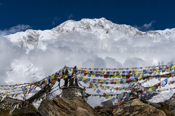 Many tibetan prayer flags are set up at a memorial for died climbers