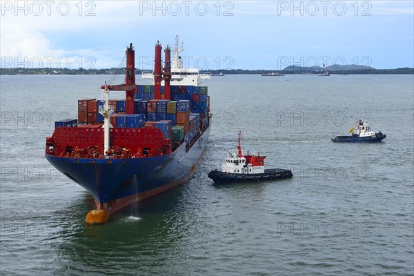 Container ship and pilot vessels berthing in the harbor