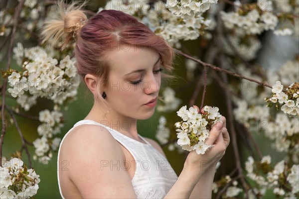 Young woman in front of cherry blossoms