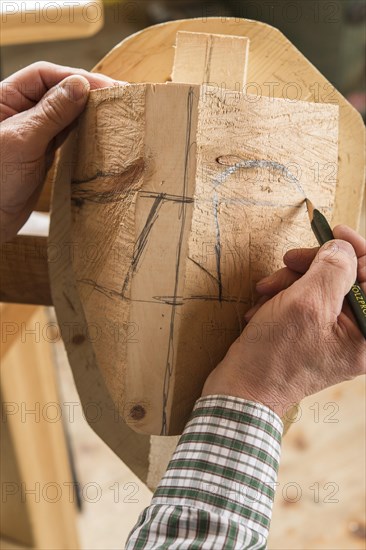 Drawing the outline of a face on a wooden block