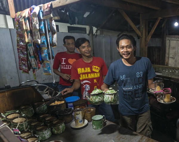 Native waiter offering tea from booth