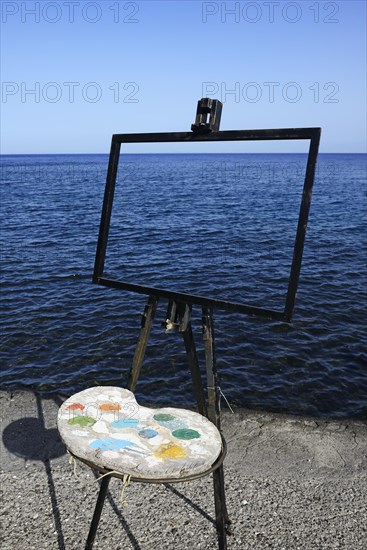 Easel and pallet in front of the sea