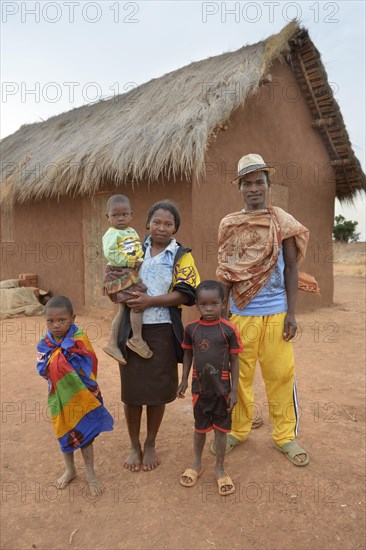 Family with three children in front of hut