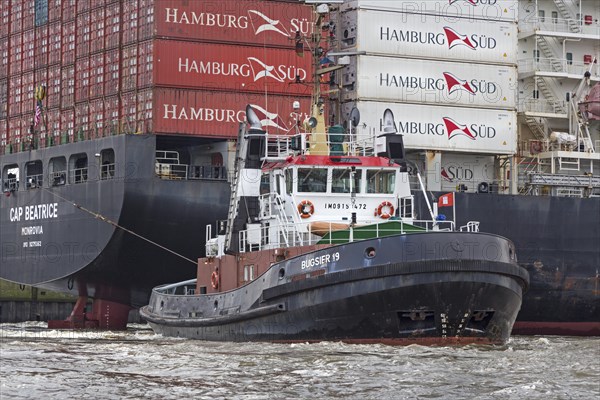 Fully loaded container ship Cap Beatrice being pulled by tugs