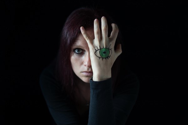 Woman with painted eye on her hands