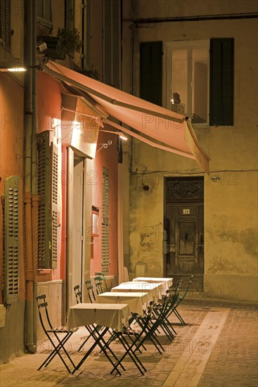 Lit outdoor street cafe by night