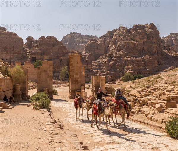 Tourist and guide on dromedaries at Temenos Gate