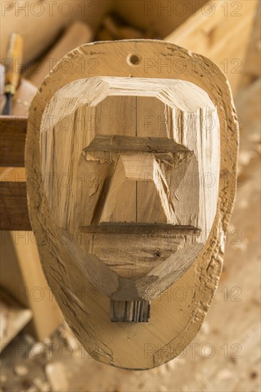 Partially shaped wooden block fixed on a workbench