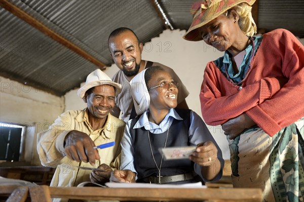 Villagers fill out applications for certification of their land on the village square