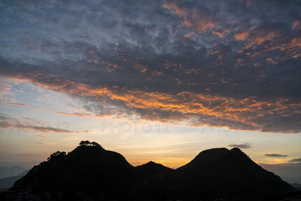 Red clouds over two hills at sunset