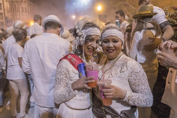 Two woman posing in front of crowd