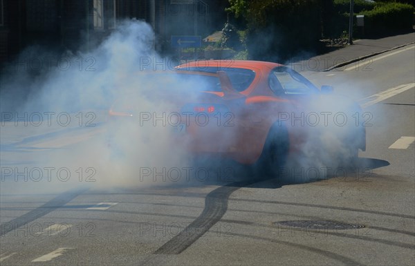 Car burning tire on a street