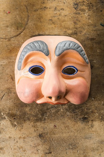 Painted wooden mask on a workbench