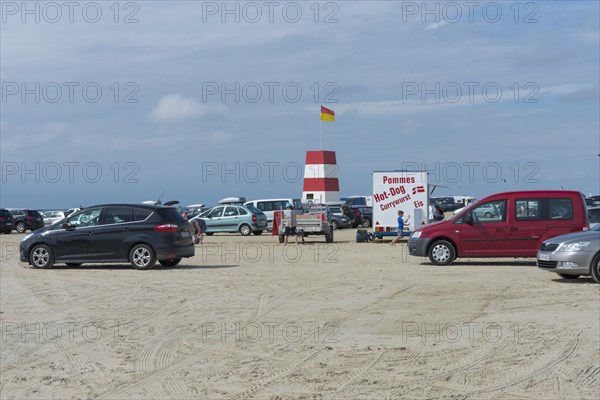 Cars parked on wide sandy beach