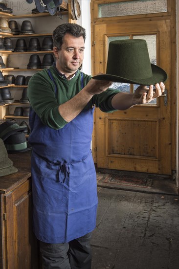 Hatter examining finished wool felt hat