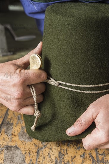 Tightening the shaping cord around a wool felt hat