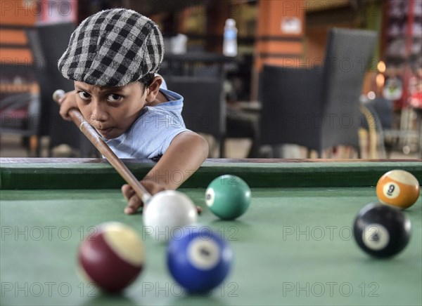 Boy playing billiards