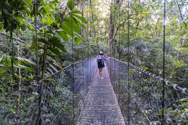 Woman walking over suspension bridge