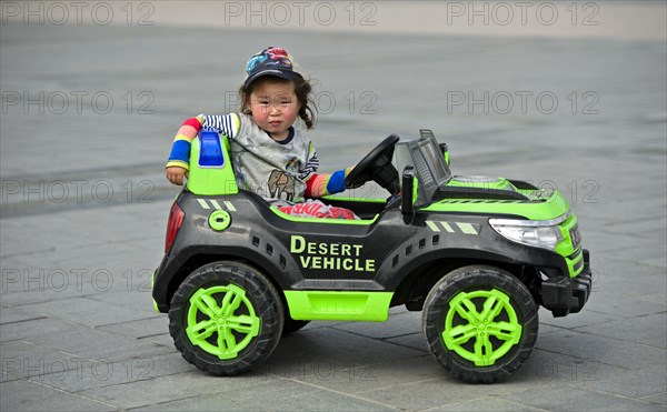 Little girl rides in electric toy car