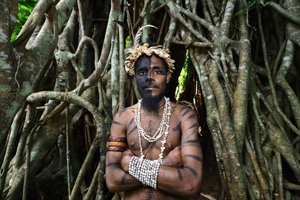 Tribal warrior in front of the roots of the banyan tree