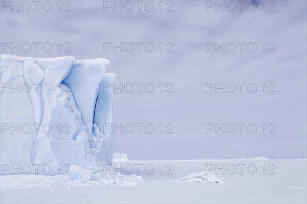 Iceberg seen from frozen fjord