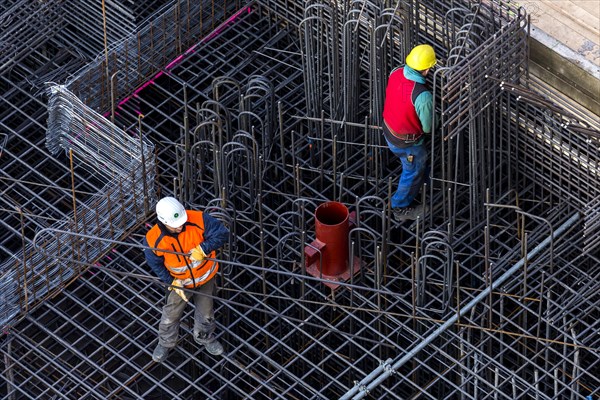 Construction workers processing reinforcing steel for reinforced concrete ceiling