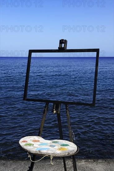 Easel and pallet in front of the sea