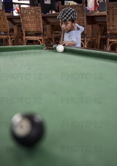 Boy playing billiards