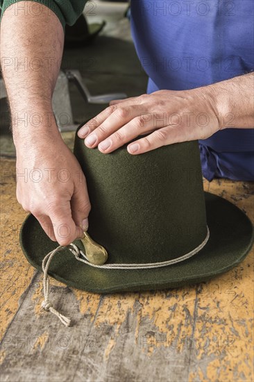 Tightening the shaping cord around a wool felt hat