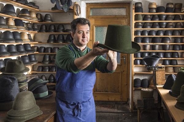 Hatter examining finished wool felt hat