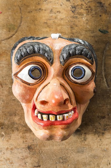 Painted wooden mask on a workbench