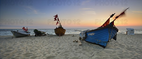 Fishing boats on beach at sunrise