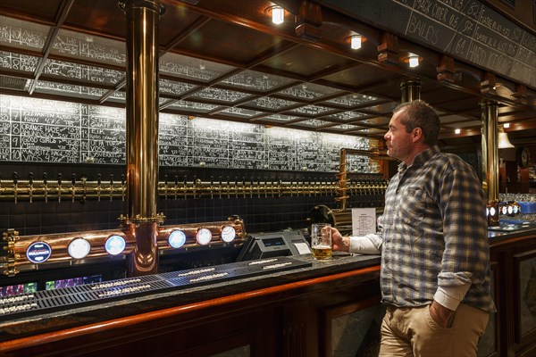 Man holding a glass of beer at Olhallen