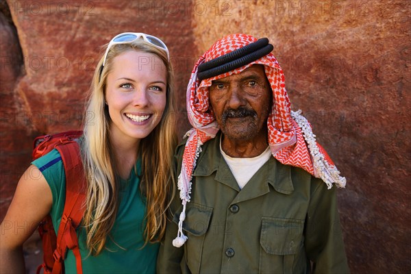 Tourist girl poses with old man