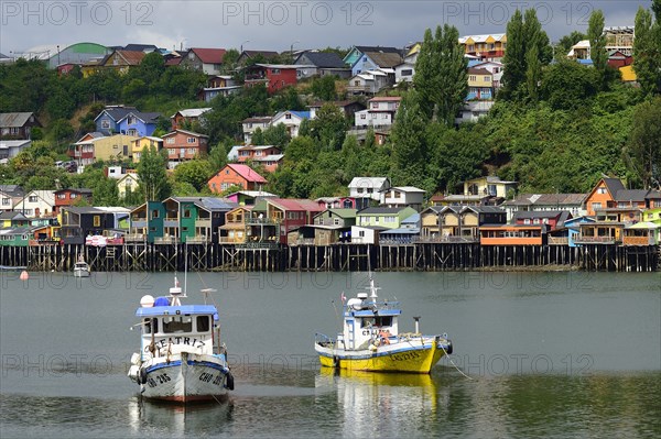 Fishing boats anchoring in front of colorful stilt houses