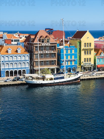 Old sailing ship in front of historic buildings in Dutch-Caribbean colonial style