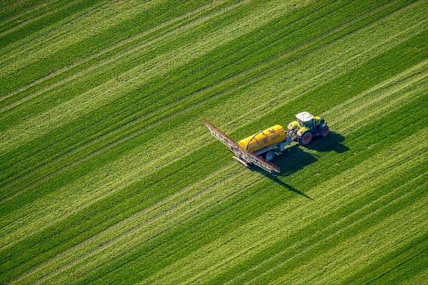 Tractor with pesticide sprayer on meadow