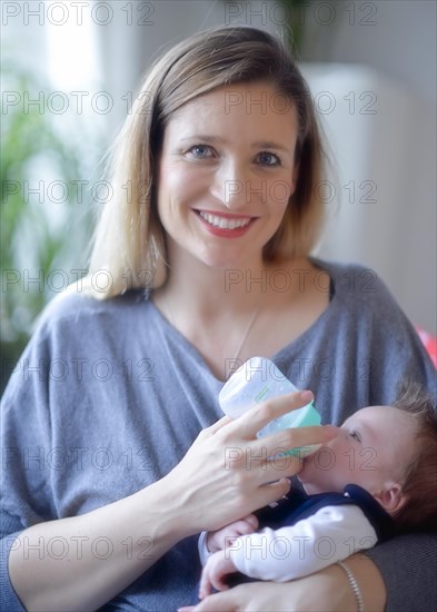 Mother feeds baby with baby bottle