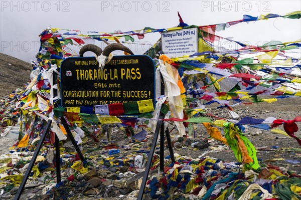 Tibetan prayer flags at sign Thorong-La Pass
