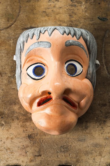 Painted wooden mask on a workbench