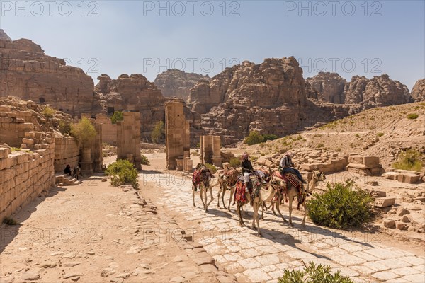 Tourist and guide on dromedaries at Temenos Gate