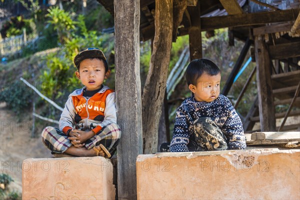 Two little boys sitting at log cabin