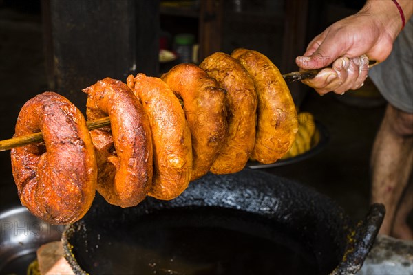 Hand holding fresh doughnuts on a wooden stick