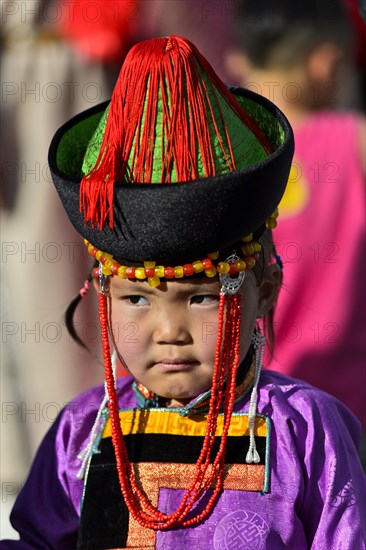 Little girl in traditional Deel clothes and hat with cone-shaped lace