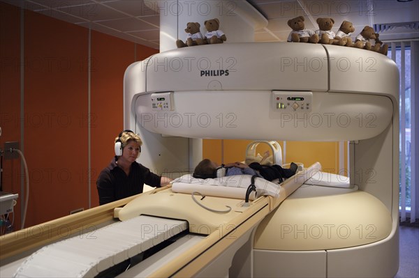 Mother with child at MRI scan on the foot